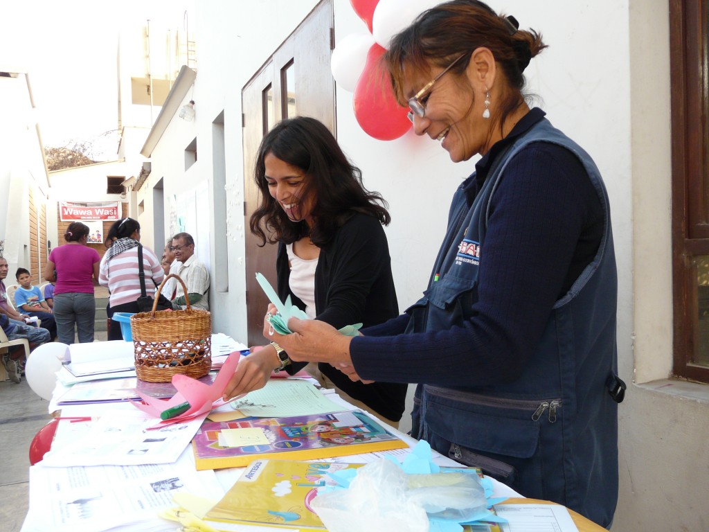 A visiting trainee helps a team member at a community workshop